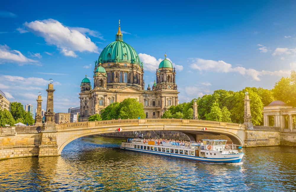 Udsigt over Berliner Dom på Museumsøen med bro og turistbåd i forgrunden