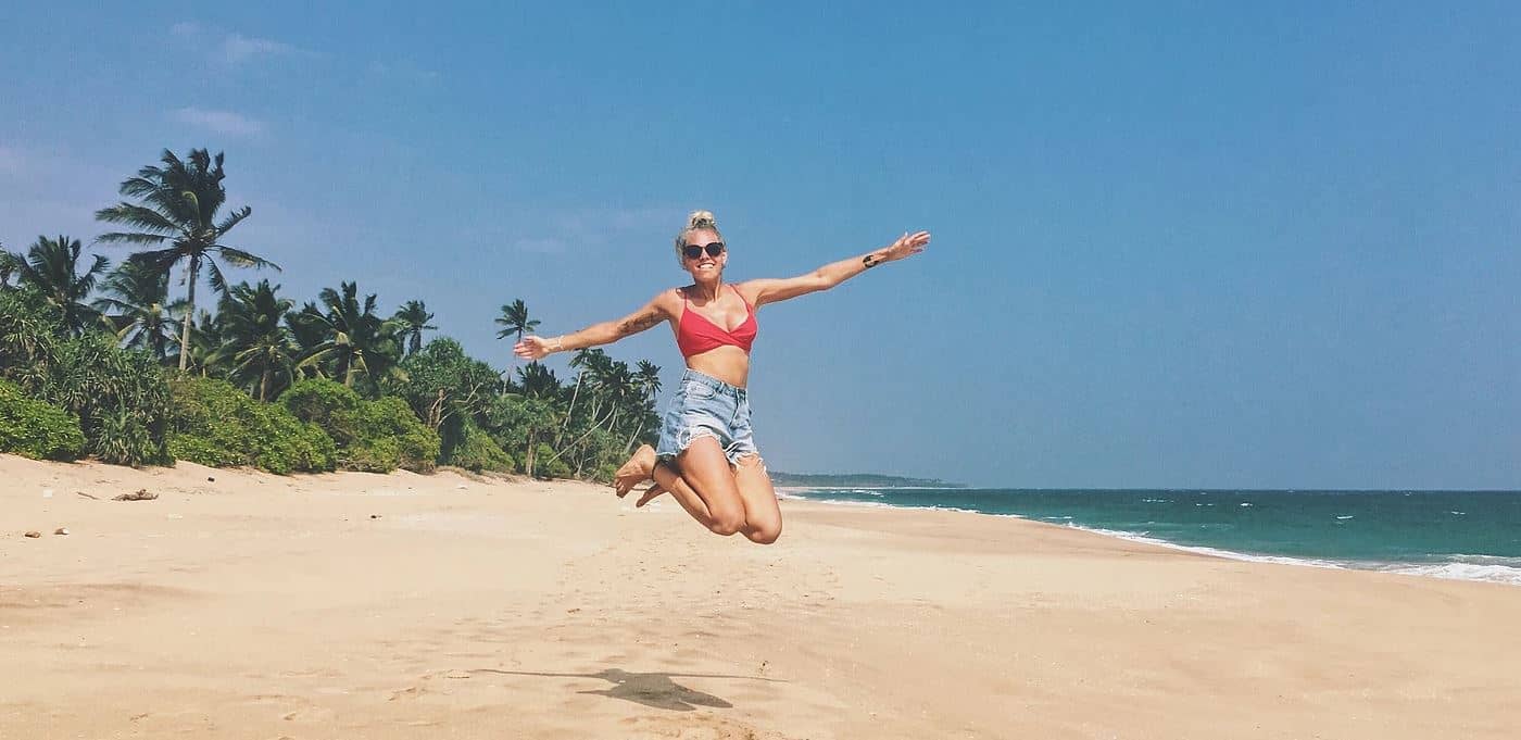 Mathilde Odgaard på Sri Lanka. Hopper på bounty strand med palmer i baggrunden og skyfri himmel.